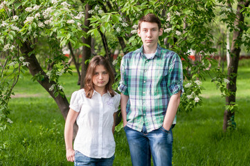 young couple walking in a flowery park on a summer day