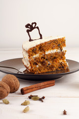 Piece of carrot cake with walnuts and white cream. 