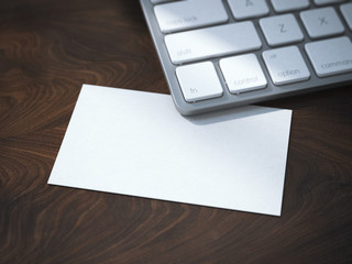 Blank white business card under keyboard