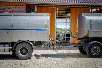Milchtankwagen mit Anhänger vor einen Milchviehstall