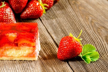 erdbeerfrüchte mit erdbeerkuchen auf einem Holztisch