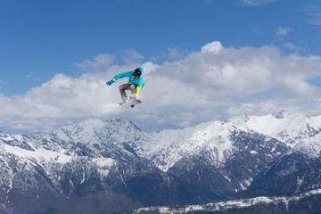 Flying snowboarder on mountains. Extreme sport.