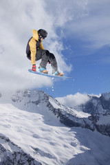 Flying snowboarder on mountains. Extreme sport.