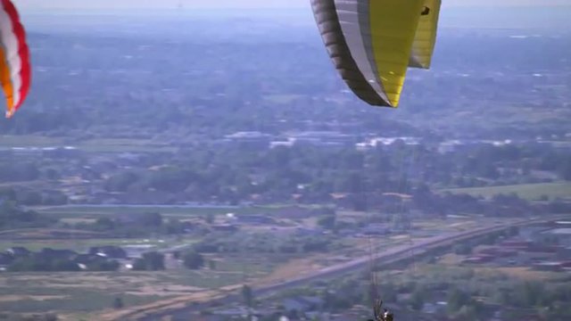 Two people paragliding from one parachute.