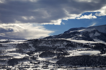 Winter mountains and village at evening