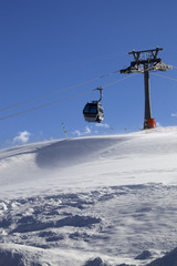 Fototapeta premium Gondola lift on ski resort at windy sun day