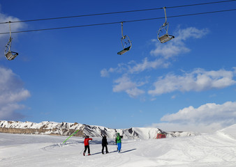 Three skiers on slope at sun nice day