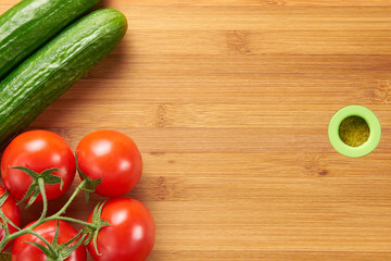 Shot of fresh tomatoes and cucumbers on a wooden chopping board