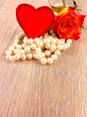 Rote Rose mit Herz und Perlenkette