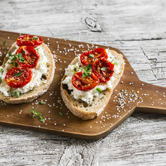 sandwich with goat cheese, sun-dried tomatoes and thyme, served on the Board at a bright wooden surface