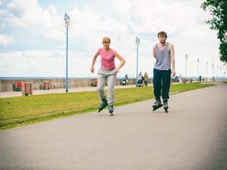 Active young people friends rollerskating outdoor.