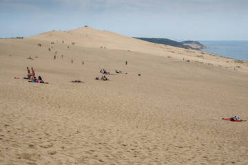 Fototapeta na wymiar sand, people and water - Dune du Pyla - sand dune at coast of Atlantic Ocean, Aquitaine, France