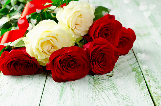 Red and white roses on wooden background