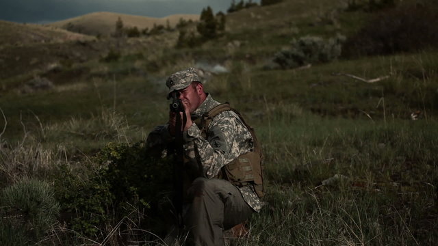 Soldier kneeling stance, with explosive smoke behind him.