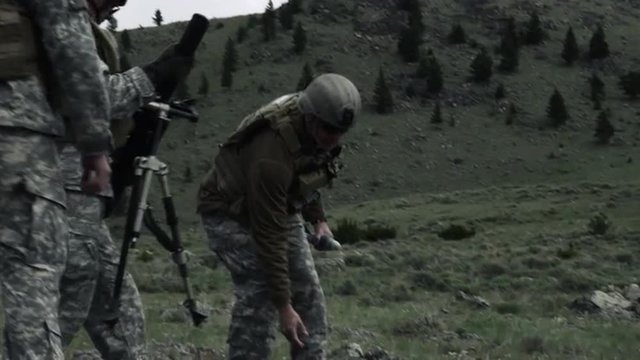 Shot of soldiers moving mortar system.