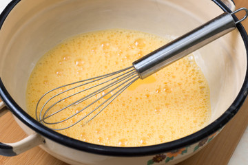 Mixed eggs in the bowl with wire