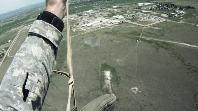 Parachutist in the sky, preparing for landing