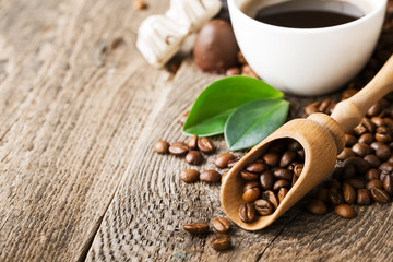 ground coffee in scoop and coffee beans on a wooden background,