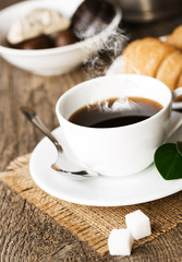 Hot coffee and pastries on a wooden background