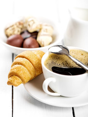 Hot cappuccino and pastries on white wooden boards