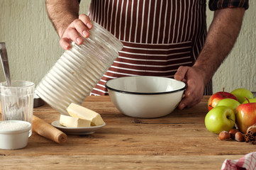 Male chef prepares a pie with apples