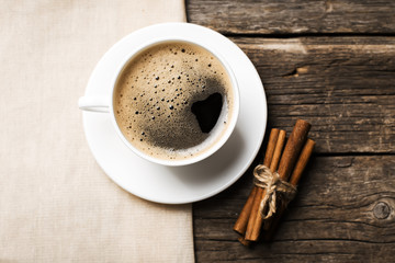 Nahaufnahme der Kaffeetasse mit gerösteten Kaffeebohnen auf Holzbackg
