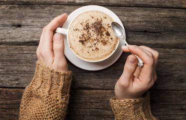 woman holding hot cup of coffee