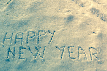 Happy New Year message on a snow field. Vintage filter applied.