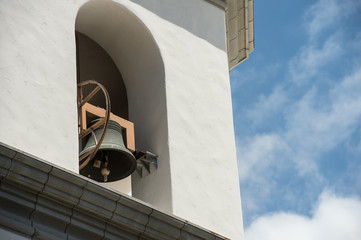 mission bell against a blue sky with white clouds