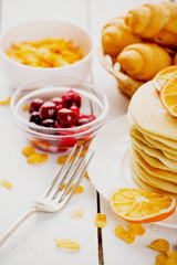 delicious pancakes on wooden table with fruits
