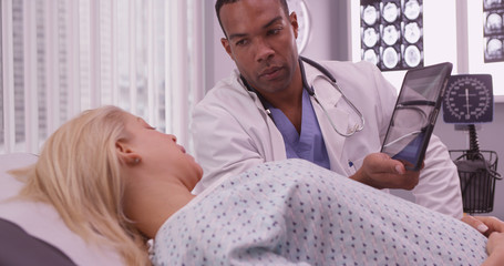 African doctor sharing woman patient's xray on tablet