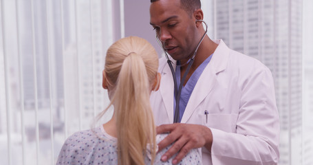 Black doctor listening to patient's heart