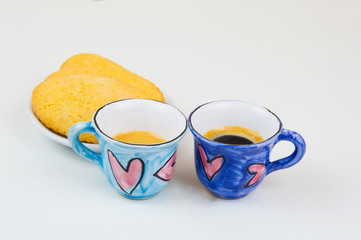 Couple of colorful coffee cups with hand draw of love heart on wood board