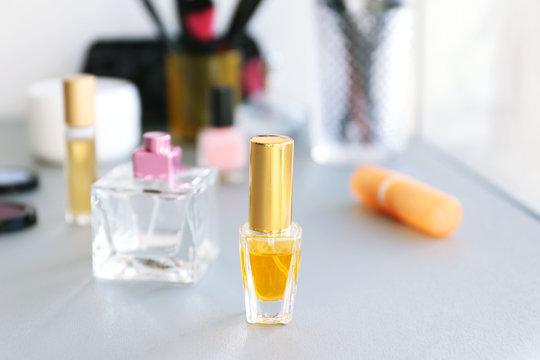 Perfume bottles with makeup tools and cosmetics on a table