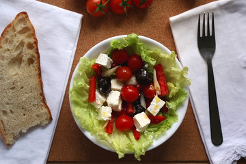 Greek salad with cherry tomatoes, red peppers, black olives,onion and feta cheese. Top view.