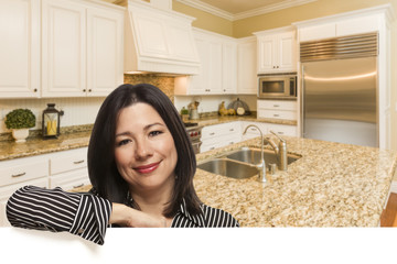 Hispanic Woman Leaning Against White In Custom Kitchen Interior