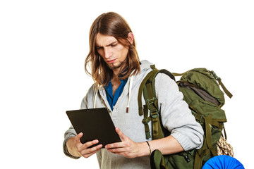 Backpacker man using pc tablet browsing internet.