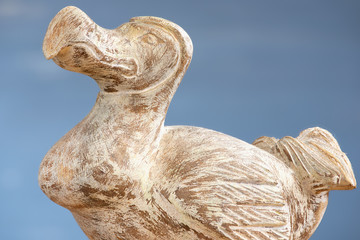 Wooden Dodo bird - typical souvenir from Mauritius island over the blue background. Dodo is an extinct flightless bird that was endemic to the island of Mauritius. © Dmitry Chulov