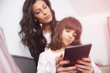 Mother and daughter looking at digital tablet