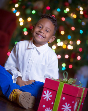 Young Boy Seated Beside Christmas Gift