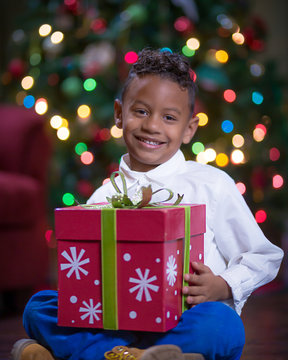 Young Boy Seated Holding Christmas Gift