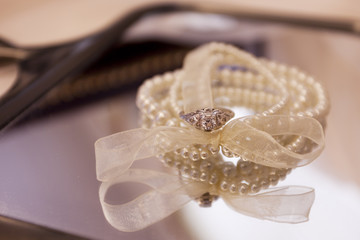 Wedding ring alongside a pearl bracelet 