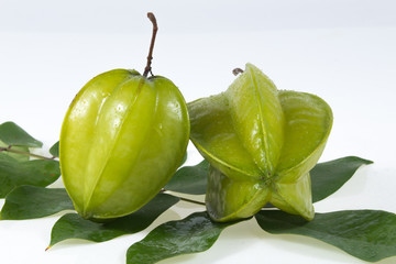 Star fruit with green leaf isolate on white background .