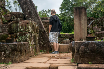 Young man stands in the ruins of a temple at My Son Sanctuary in