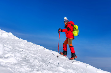 Young woman hiking on high mountains in winter.