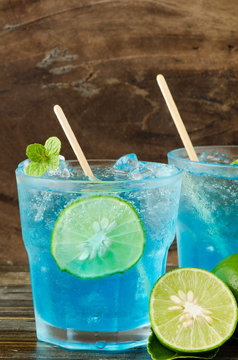 Ice blue drink with lemon on wooden background