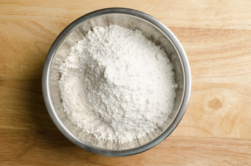 Fototapeta na wymiar Flour in the bowl on wooden background,food ingredient