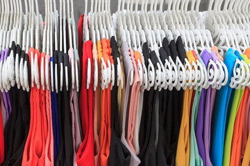 Choice of fashion clothes of different colors on hangers