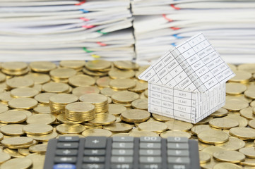 Pile of gold coins with house on stack gold coins