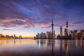 Fototapeta na wymiar waterfront cityscape and illuminated skyline at dawn